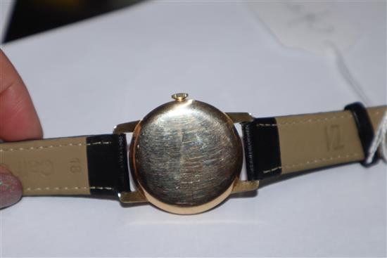 A gentlemans 14k Huguenin manual wind wrist watch, on associated leather strap.